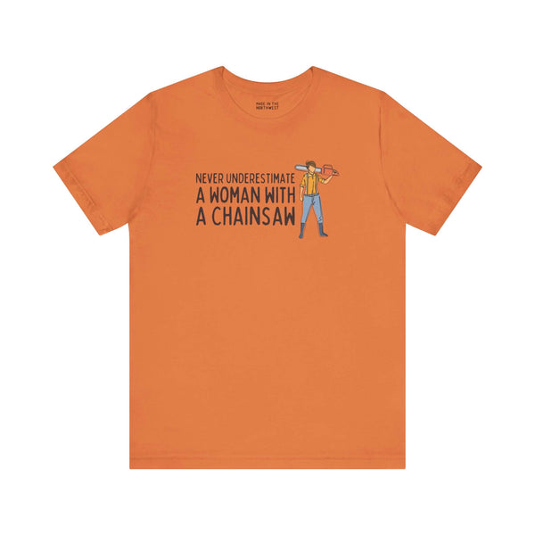 Never Underestimate a Woman with a Chainsaw Premium Soft Tee in orange, showcasing confidence and strength.