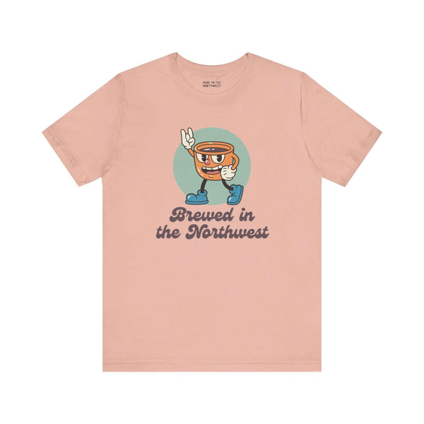 Brewed in the Northwest coffee tee featuring a cheerful coffee cup design on a soft pink shirt.