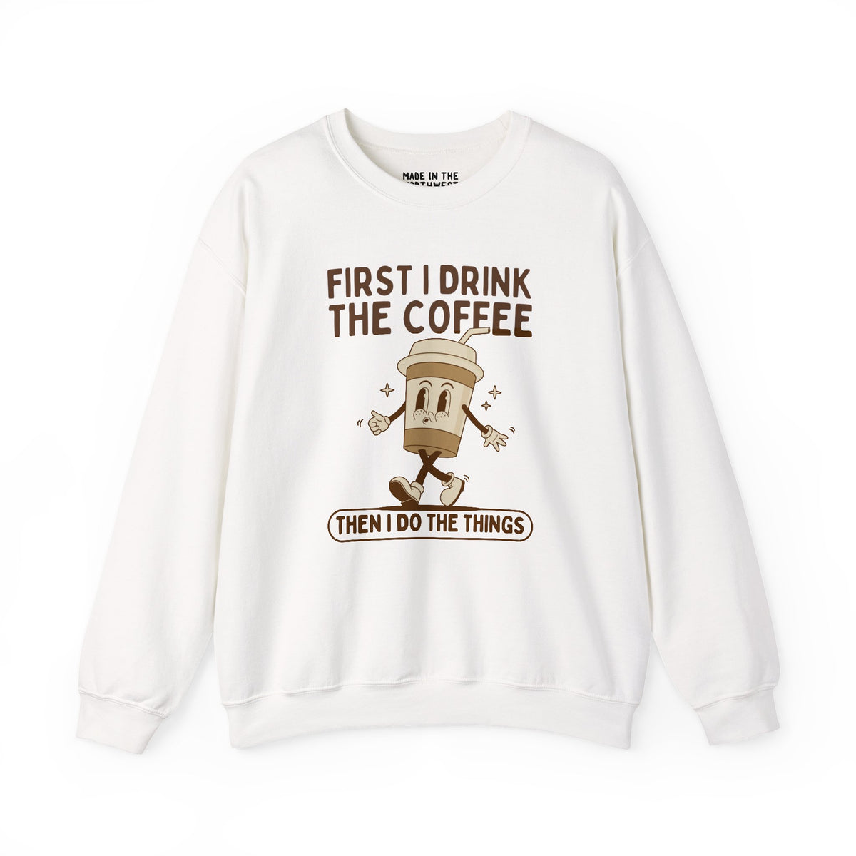 Light-colored sweatshirt featuring 'First I Drink the Coffee Then I Do the Things' coffee cup design.