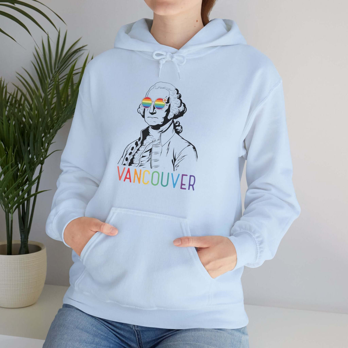 Person wearing George's Rainbow Vision Vancouver Hoodie with rainbow lettering and George Washington in rainbow glasses.