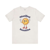 Manifest Sunshine T Shirt featuring a cartoon sun with peace signs and hand-lettered text.