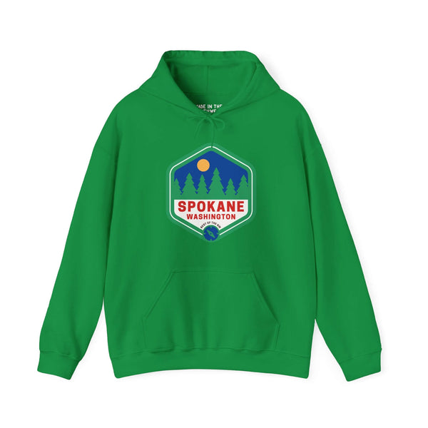 Green Spokane Washington hoodie with retro 90s badge featuring trees, celebrating outdoor beauty and community spirit.