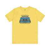 Yellow soft tee featuring the illustration of a BMW E30 with the text 'A Driving Machine for the Sensible Fanatic'.