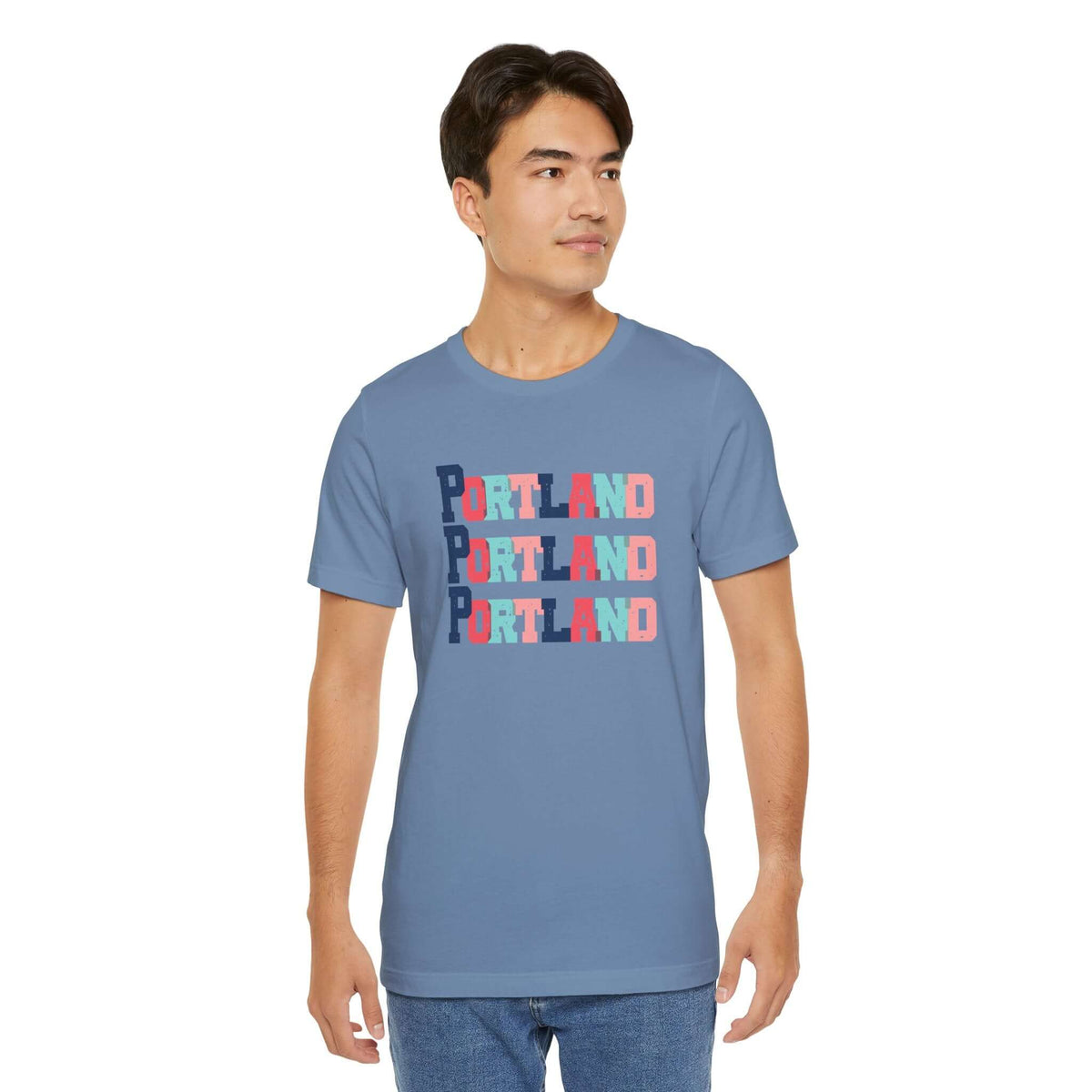 "Man wearing Bold and Bright Portland Trio Soft Tee in blue with colorful block-letter city design"