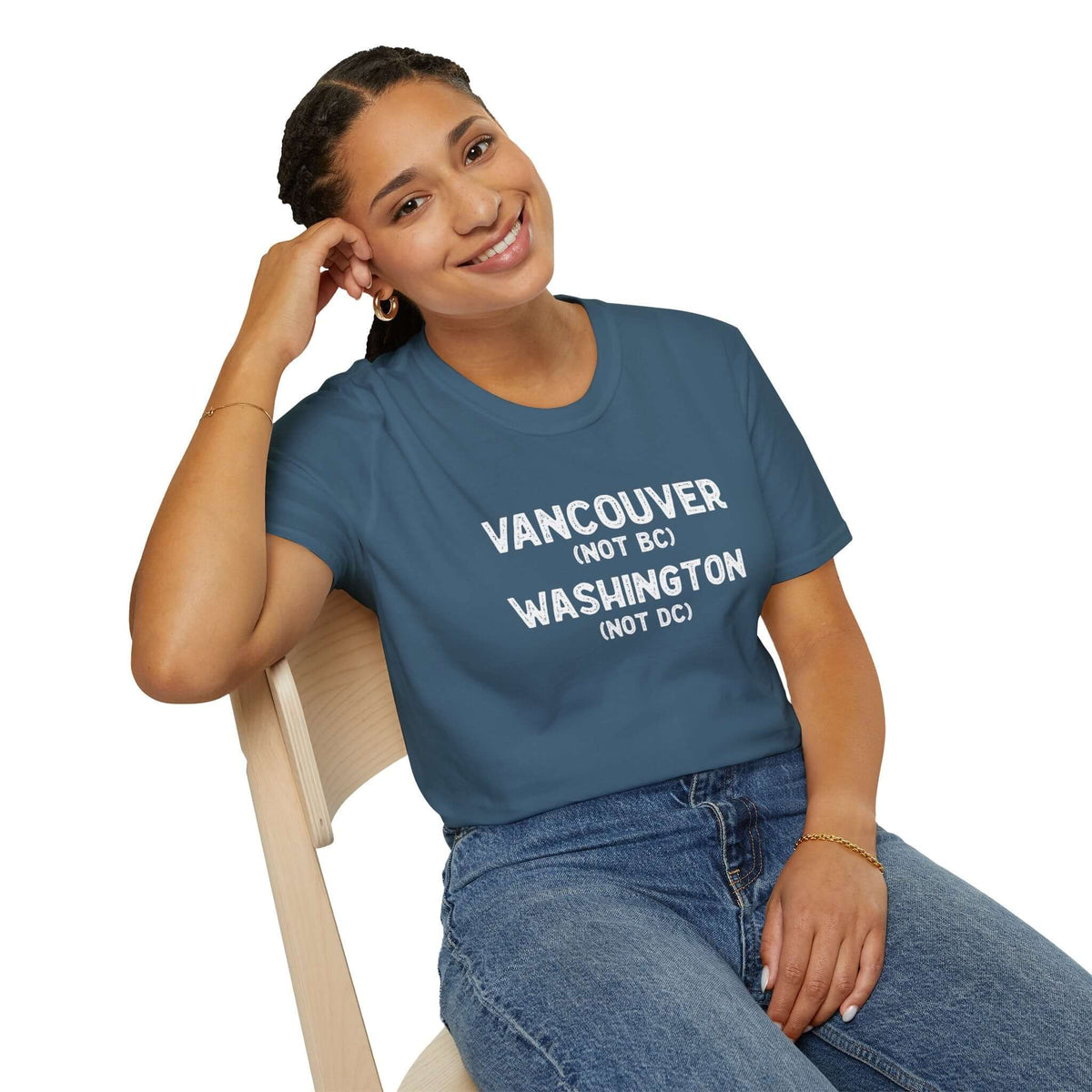 Smiling woman wearing a Vancouver (Not BC) Washington (Not DC) softstyle t-shirt, seated on a chair.