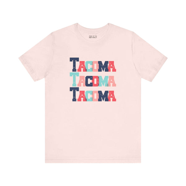 Bold and Bright Tacoma Trio Soft Tee with colorful block-letter city name design on cream fabric.