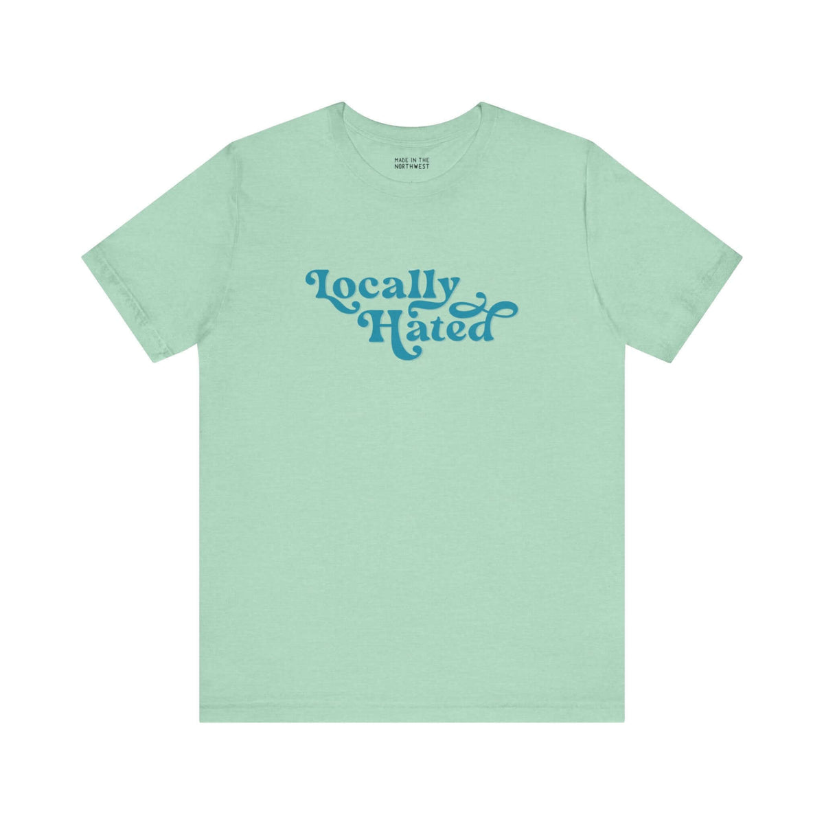 Light green "Locally Hated" soft tee with bold cursive font, designed for those who stand out in the Pacific Northwest.