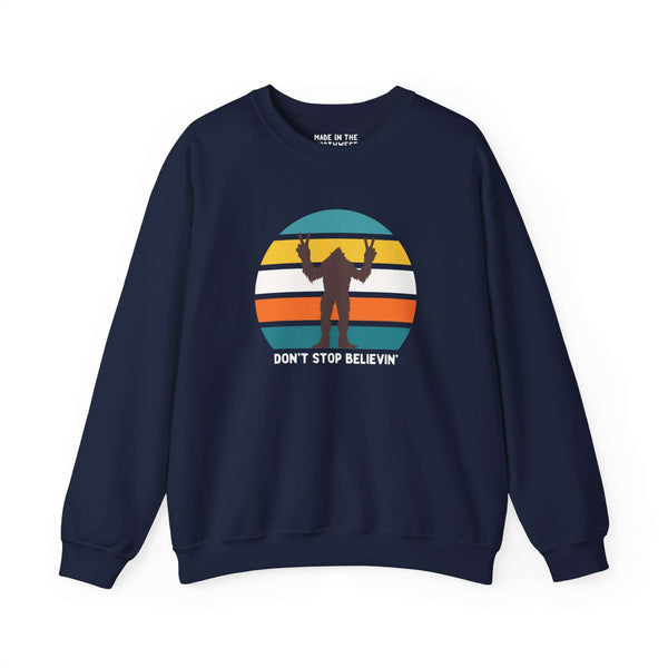 Navy sweatshirt featuring Bigfoot graphic and 'Don't Stop Believin'' text, inspired by Pacific Northwest folklore.