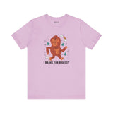 Light pink t-shirt featuring a whimsical Sasquatch graphic and the text 'I Brake for Bigfoot'.
