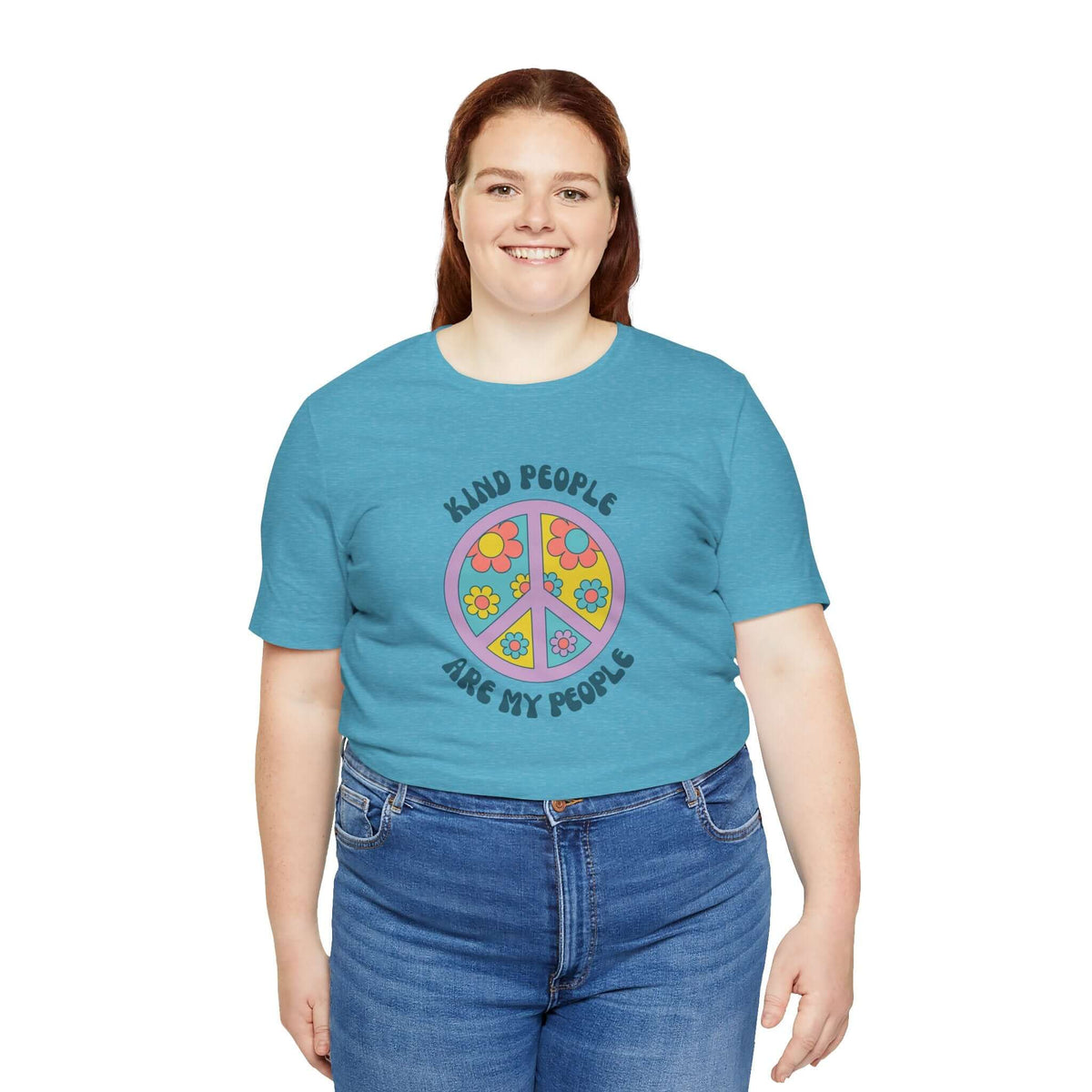 Woman wearing a teal unisex premium tee with a floral peace sign and the text 'Kind People Are My People'.