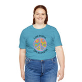 Woman wearing a teal unisex premium tee with a floral peace sign and the text 'Kind People Are My People'.