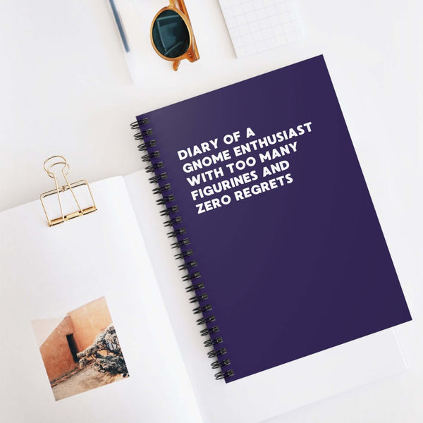 Spiral notebook titled 'Diary of a Gnome Enthusiast' with a purple cover on a desk.