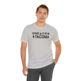 Home is in Tacoma tee worn by a man, showcasing Tacoma's pride with campfire and tree designs.