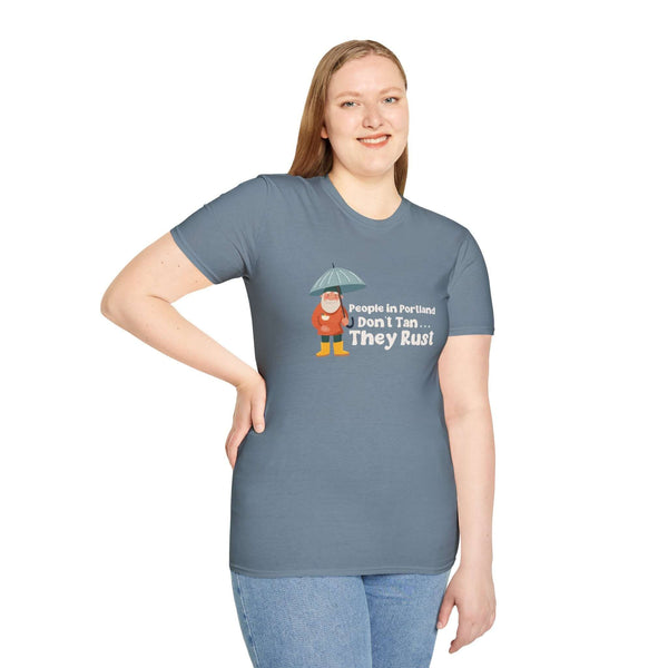 Woman wearing blue t-shirt with "People in Portland Don't Tan, They Rust" graphic showcasing Portland's rainy vibe.