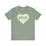 PNW Explorer's Heart Premium Soft Tee featuring a map heart design and bold 'PNW' text on a soft green shirt.