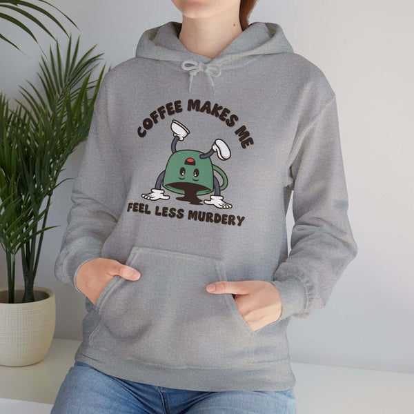 Woman wearing "Coffee Makes Me Feel Less Murdery" hoodie, perfect for coffee lovers with a humorous twist.