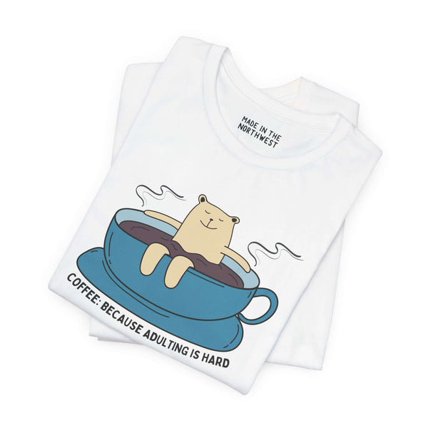 Premium soft tee featuring a cute bear in a coffee cup with the text 'Coffee: Because Adulting is Hard'.