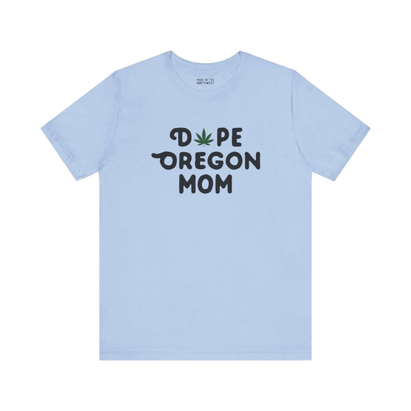 Light blue tee with "Dope Oregon Mom" text, featuring a marijuana leaf symbol replacing the "O" in "Dope."