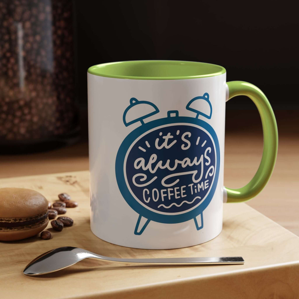 It's Always Coffee Time Mug with a green handle and cheerful clock graphic on a wooden table.