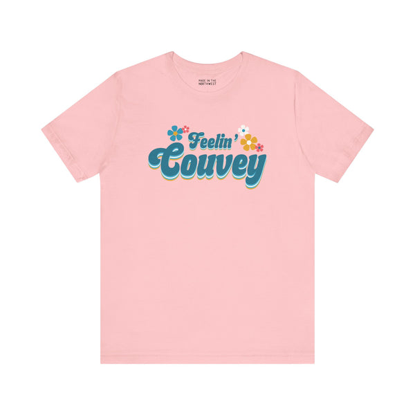 Feelin' Couvey retro premium soft tee in pink featuring 70s font and colorful flowers, celebrating Vancouver's spirit.