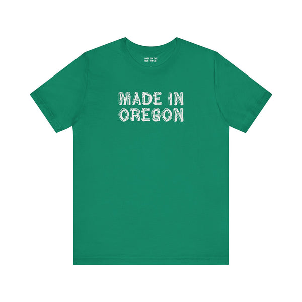 Green tee featuring rustic 'Made in Oregon' log font, perfect for outdoor lovers and Pacific Northwest pride.