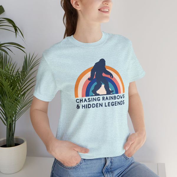 Woman wearing a light blue tee with a Sasquatch graphic and rainbow design, promoting local pride and vintage style.