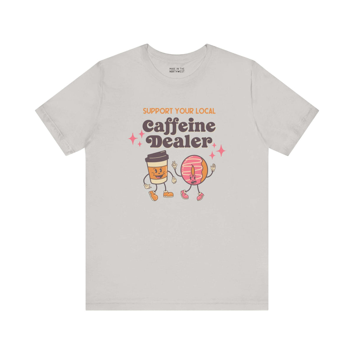 "Support Your Local Caffeine Dealer coffee tee with fun graphic design, featuring coffee cup and donut characters on a soft gray fabric."