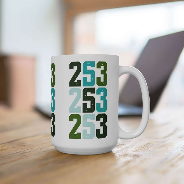 Two-Five-Three Pop Tacoma ceramic mug with vibrant area code design on wooden table.