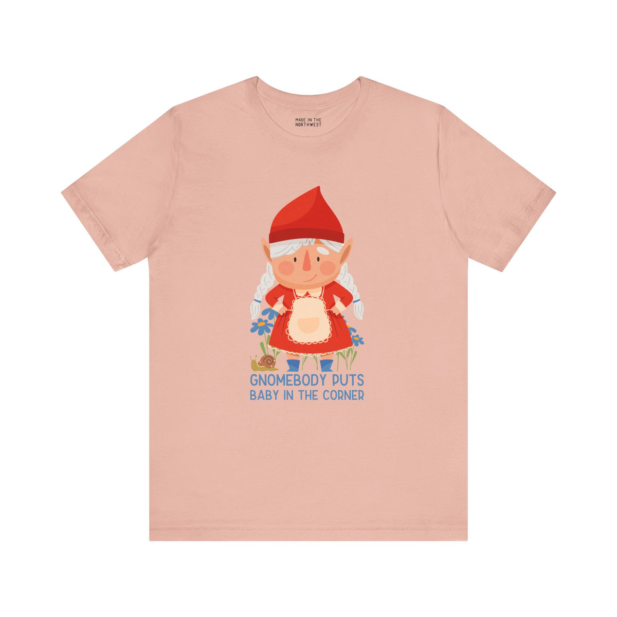 Light pink t-shirt featuring a playful gnome and the phrase 'Gnomebody Puts Baby in the Corner' for fun wardrobe flair.