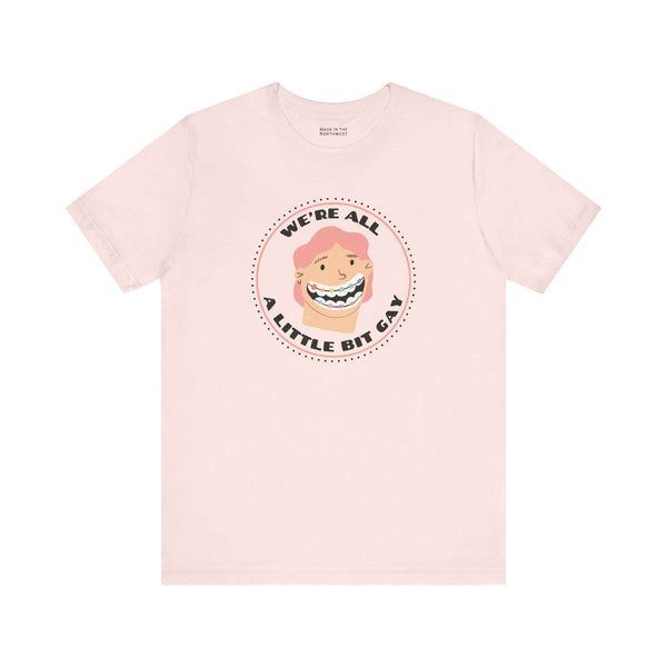 We're All a Little Bit Gay Tee featuring playful design and bold lettering on a soft pink shirt.