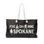 Five Oh Nine Roots Spokane Weekender Bag featuring graphics of a tree, sasquatch, and small axe on a stylish black tote.