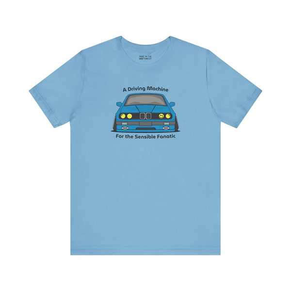 Light blue tee featuring BMW E30 325is design with 'A Driving Machine for the Sensible Fanatic' text.