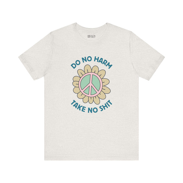 Premium soft tee featuring a peace flower design with 'Do No Harm, Take No Shit' slogan for a bold, uplifting style.