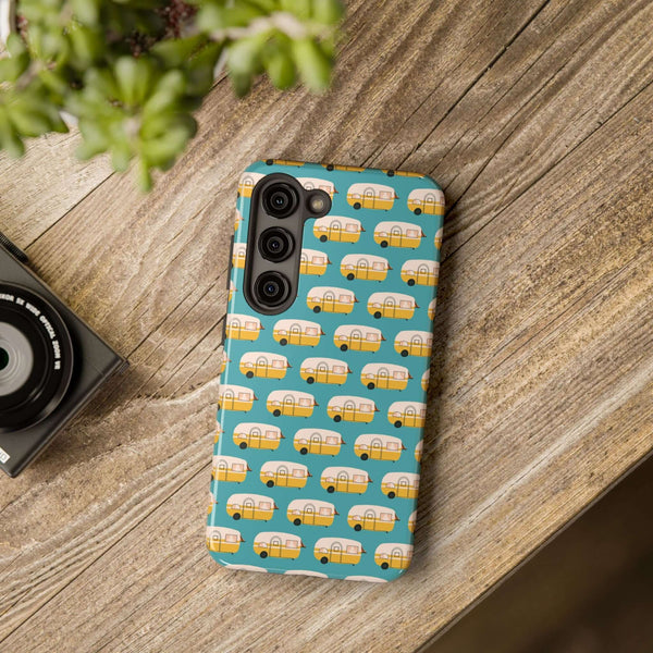 Happy Camper tough phone case with vintage camper design on a wooden table, perfect for adventure lovers.