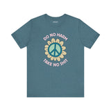 Do No Harm Take No Shit Tee featuring a bold peace flower design on a blue shirt.
