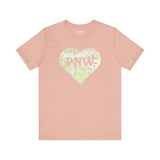 PNW Explorer's Heart Premium Soft Tee in pink with topo map design and 'PNW' logo, perfect for outdoor adventures.