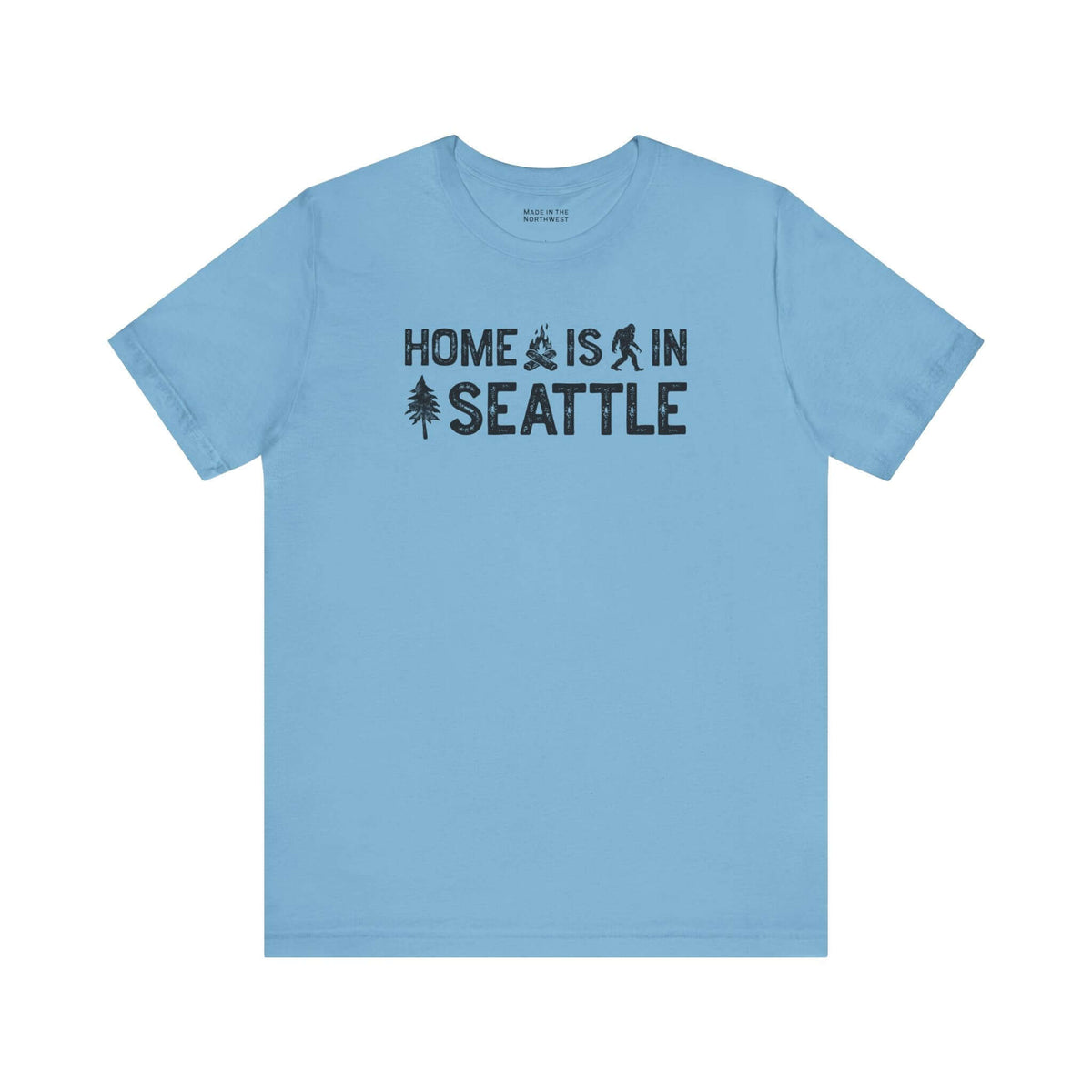 Home Is in Seattle Tee in blue with campfire, Bigfoot, and tree design, representing Emerald City pride.