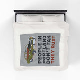 People in Portland Don't Tan They Rust Lightweight Cozy Blanket displayed on a bed with vintage car design.