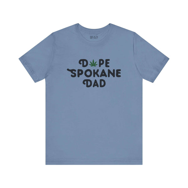 Blue "Dope Spokane Dad" tee with a marijuana leaf in place of the "O," celebrating unique style and local pride for Spokane dads.