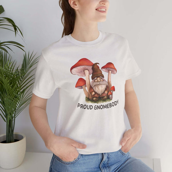 Woman wearing a Proud Gnomebody tee with gnome and mushrooms design, perfect for cozy home vibes.