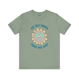 Do No Harm Take No Sh!t premium soft tee with peace flower design on a muted green shirt.