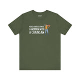 Olive green tee featuring the phrase 'Never Underestimate a Woman with a Chainsaw' and an illustration of a woman with a chainsaw.