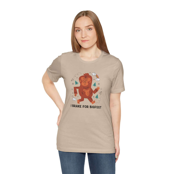 Woman wearing I Brake for Bigfoot premium soft tee featuring whimsical Sasquatch graphic.