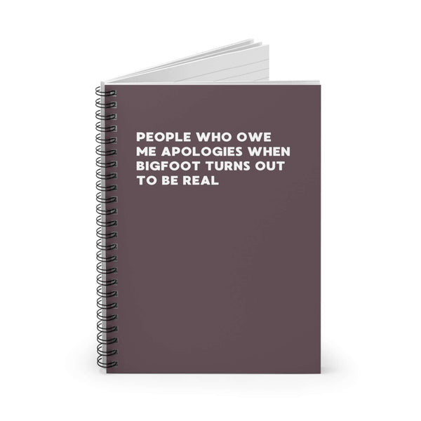 Spiral notebook titled 'People Who Owe Me Apologies When Bigfoot Turns Out to Be Real' on a dark background.