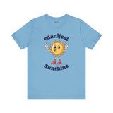 Manifest Sunshine T Shirt featuring a cartoon sun and positive vibes design on a light blue background.