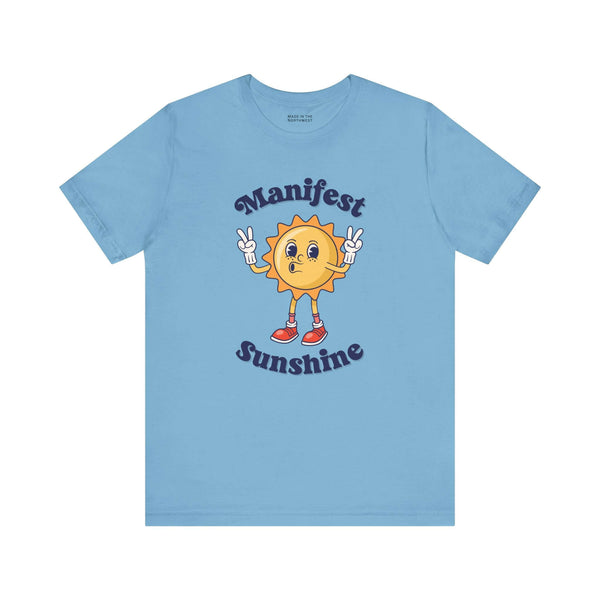 Manifest Sunshine T Shirt featuring a cartoon sun and positive vibes design on a light blue background.