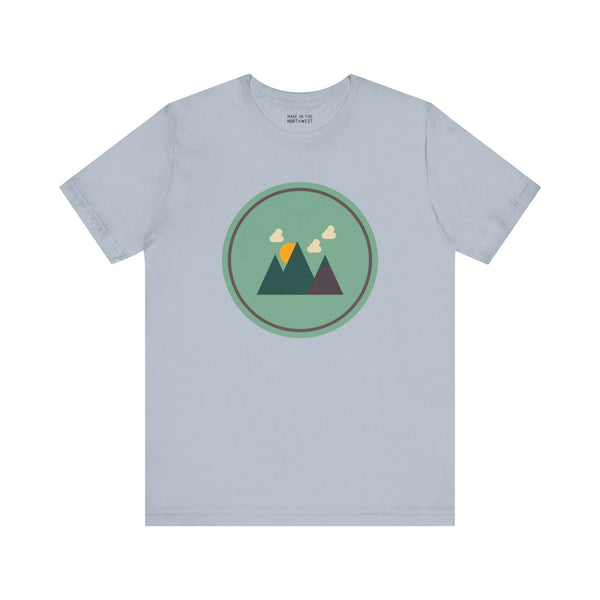 Minimalist forest silhouette tee in Northwest style featuring mountains on a soft blue shirt, perfect for nature lovers.