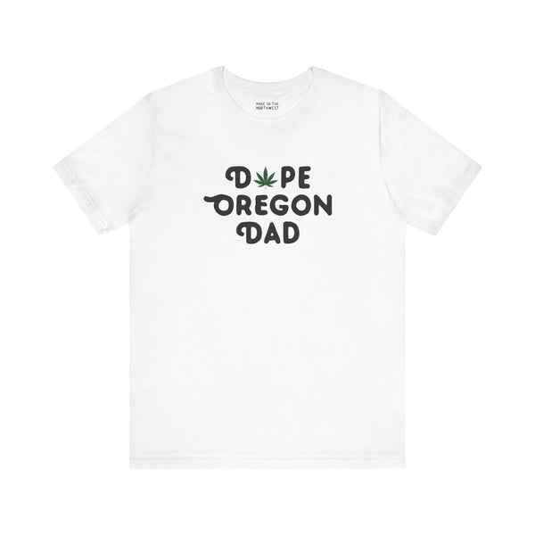 White tee featuring 'Dope Oregon Dad' text with marijuana leaf in place of 'O' for a chill, local vibe.