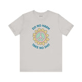 Do No Harm Take No Shit Tee featuring a peace flower design on a light gray t-shirt.