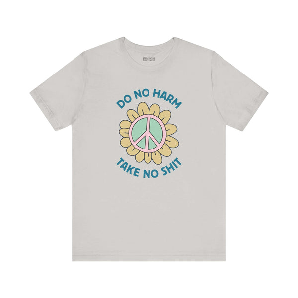 Do No Harm Take No Shit Tee featuring a peace flower design on a light gray t-shirt.
